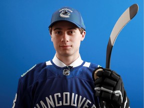 Quinn Hughes poses after being selected seventh overall by the Vancouver Canucks during the first round of the 2018 NHL Draft at American Airlines Center on June 22, 2018 in Dallas, Texas.