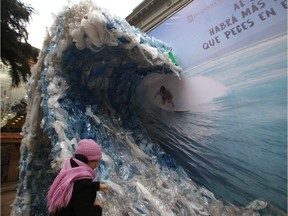 A billboard portrays a wave made of plastic bags.