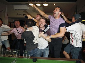 England supporters celebrate Harry Kane's winning goal as fans watch the World Cup soccer match between Tunisia and England at the Lord Raglan Pub in London, Monday, June 18, 2018.