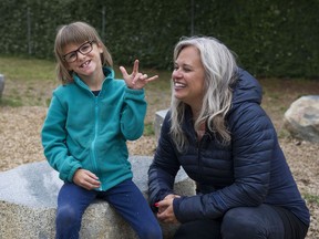 Heather Ratzlaff's daughter Keira, 8, signs to the photographer taking her photo Tuesday in a Burnaby park.