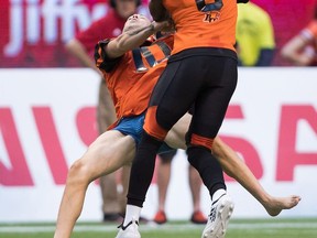 B.C. Lions' Marcell Young (8) knocks down a spectator that ran onto the field of play during the first half of a CFL football game against the Montreal Alouettes in Vancouver, on Saturday June 16, 2018.