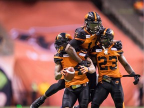 B.C. Lions' Garry Peters, from left to right, Odell Willis and Anthony Thompson, celebrate Peters' interception against the Montreal Alouettes in CFL action on June 16 in Vancouver.