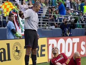Real Salt Lake's Fabian Espíndola, right, jokes with referee's assistant Joe Fletcher during the second half of play in a MLS soccer match, Saturday, May 12, 2012, in Seattle.