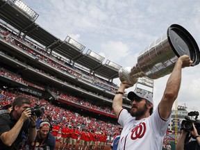 Washington Capitals' Alex Ovechkin, from Russia, lifts the Stanley Cup on the field before a baseball game between the Washington Nationals and the San Francisco Giants at Nationals Park, Saturday, June 9, 2018, in Washington.