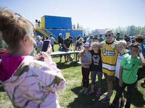 Former Humboldt Broncos player Kaleb Dahlgren takes a photo with some fans during a Saskatchewan Roughrider practice and autograph session at Glen Hall Park in Humboldt, SK on Sunday, June 3, 2018.