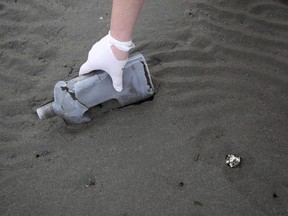 A volunteer collects a plastic bottle during trash collection on a wetland earlier this year. A B.C. non-profit group has launched a pilot project to start collecting some of the toughest plastics to recycle such as potato chip bags, zipper-lock sandwich bags and six-pack rings.