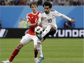 Mario Fernandes and Egypt's Mohamed Salah, right, battle for possession in Russia's 3-1 win in a Group A match between at the 2018 soccer World Cup in St. Petersburg Tuesday.