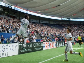 Alphonso Davies of the Vancouver Whitecaps, left, and Nicolas Mezquida celebrate Davies' goal against Orlando City during the second half of Saturday's MLS game in Vancouver. The Whitecaps won 5-2.