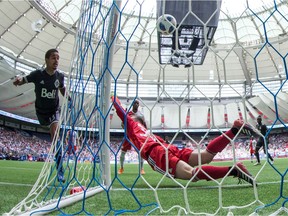 Vancouver Whitecaps' Cristian Techera, left, scores his second goal against New England Revolution keeper Matt Turner during a May 26 game at B.C. Place Stadium. Techera scored a hat trick, the first by the team in nearly five years.