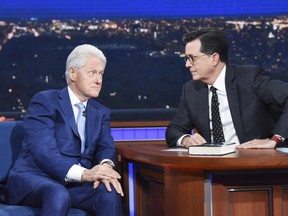In this image released by CBS, former President Bill Clinton, left, appears with host Stephen Colbert while promoting his book "The President is Missing," on "The Late Show with Stephen Colbert," Tuesday, June 5, 2018 in New York.