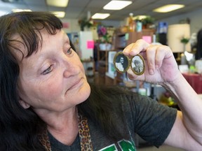 Teresa Thompson holds a vintage locket with photos of a girl and a boy.