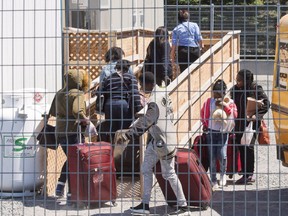 A group of asylum seekers arrive at the temporary housing facilities at a border crossing in Quebec.