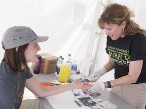 A woman provides a sample for a hepatitis C test. Testing is the key to eradicating the disease.