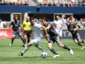 Vancouver Whitecaps midfielder Efrain Juarez (r) battles Seattle Sounder Cristian Roldan (l)