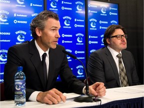 Trevor Linden (L) delivers remarks as Vancouver Canucks owner Francesco Aquilini looks on during a press conference in 2014.