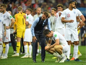 England's coach Gareth Southgate (C-L) comforts England's defender Harry Maguire (C-R) at the end of the Russia 2018 World Cup semi-final football match between Croatia and England at the Luzhniki Stadium in Moscow on July 11, 2018.