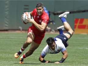 Canada's Justin Douglas, left, runs past Japan's Dai Ozawa to score during the Rugby Sevens World Cup in San Francisco, Saturday, July 21, 2018.