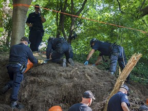 Members of the Toronto Police Service excavate the back of property along Mallory Cres. in Toronto after confirming they have found human remains during an investigation in relation to alleged serial killer Bruce McArthur on Thursday, July 5, 2018.
