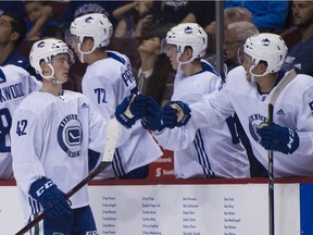 Tyler Madden taps the gloves of his Team White teammates on the bench after scoring on Team Blue  in the first period of the Vancouver Canucks annual Showcase game at Rogers Arena on Thursday.