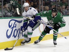 Defenceman Derrick Pouliot of the Vancouver Canucks, left, may be one of the players impacted if rookie Quinn Hughes makes the NHL squad this season.
