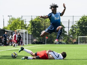 Vancouver Whitecaps midfielder Georges Mukumbilwa jumps over a New England Revolution player in a friendly game between the two academy U-19 teams at UBC earlier this year.