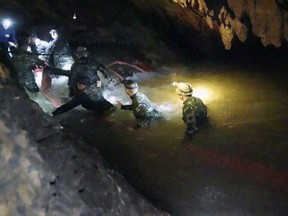 In this handout photo released by Tham Luang Rescue Operation Center, Thai rescue teams walk inside cave complex where 12 boys and their soccer coach went missing, in Mae Sai, Chiang Rai province, in northern Thailand, Monday, July 2, 2018. (Tham Luang Rescue Operation Center via AP)