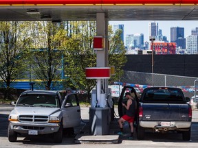 Motorists fuel up vehicles at a Vancouver gas station. Municipal and provincial politicians are pointing fingers over who is to blame for rising prices.