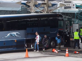 Passengers place their luggage on a Greyhound bus before departing from Vancouver.