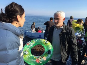 Frank Giustra among Syrian refugees on a beach on the Grek island of Lesbos.