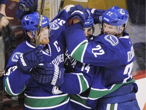 Alex Burrows celebrates a Canucks goal with linemates Henrik and Daniel Sedin, a pretty common occurrence for many years in Vancouver.
