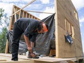 Johnny Lee works on a "Carver's Cabin" at the Camp Cloud protest site outside the Kinder Morgan terminal in Burnaby in May.