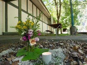 Flowers mark the spot where a woman was found dead Monday in a clothing donation bin outside Point Grey Community Centre in Vancouver.