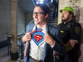Prime Minister Justin Trudeau shows off his costume as Clark Kent, alter ego of comic book superhero Superman, as he walks through the House of Commons last October.