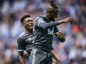 Vancouver Whitecaps' Kei Kamara, front, and Alphonso Davies celebrate Kamara's second goal against the Chicago Fire during the second half of an MLS soccer game in Vancouver, on Saturday July 7, 2018.