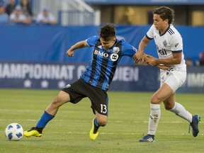 Ken Krolicki of the Montreal Impact is grabbed by David Norman Jr. of the Vancouver Whitecaps during the first game of the home-and-home Canadian Championship semifinals in Montreal.