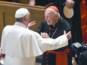 FILE - In this Sept. 23, 2015 file photo, Pope Francis reaches out to hug Cardinal Archbishop emeritus Theodore McCarrick after the Midday Prayer of the Divine with more than 300 U.S. Bishops at the Cathedral of St. Matthew the Apostle in Washington. Pope Francis has accepted U.S. prelate Theodore McCarrick's offer to resign from the College of Cardinals following allegations of sexual abuse, including one involving an 11-year-old boy, and ordered him to conduct a "life of prayer and penance" in a home to be designated by the pontiff until a church trial is held, the Vatican said Saturday.