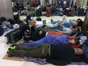 Foreign tourists sleep on the floor as they are stranded at Lombok International Airport following an earthquake in Praya, Lombok Island, Indonesia, Monday, Aug. 6, 2018. The powerful earthquake flattened houses and toppled bridges on the Indonesian tourist island of Lombok, killing a large number of people and shaking neighboring Bali, as authorities said that rescuers still hadn't reached some devastated areas and the death toll would climb.