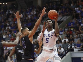 Duke Blue Devils' R.J. Barrett, right, puts up a shot against Ryerson Rams' Nathan Culbreath during their exhibition basketball game in Mississauga on Wednesday. THE CANADIAN PRESS/Mark Blinch