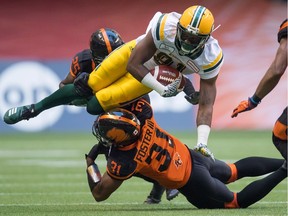 Edmonton Eskimos' D'haquille Williams is upended by B.C. Lions' Otha Foster III (31) during first-half, CFL action in Vancouver on Aug. 9. The Lions head to Toronto to visit the Boatmen Saturday, where they'll look to continue their defensive resurgence and finally win on the road this season.