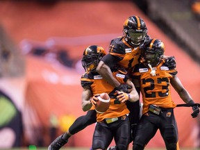 B.C. Lions' Garry Peters, from left to right, Odell Willis and Anthony Thompson celebrate Peters' interception against the Montreal Alouettes during the second half of a CFL football game in Vancouver, on Saturday June 16, 2018.