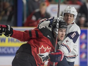Team Canada's Michael Rasmussen, left, checks Team USA Jack Drury during first period action at the Sandman Centre in Kamloops on Tuesday July 31,2018.