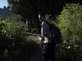 Omer Malik, 19, takes a last look back toward the United States before crossing illegally into Canada at the end of Roxham Road in Champlain, N.Y., on July 18. MUST CREDIT: Photo for The Washington Post by Andre Malerba N/A