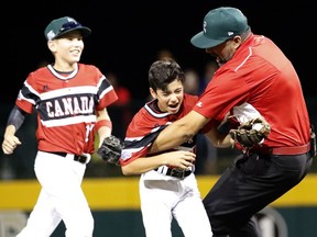 Canada's Zaeden Pleasants, pitcher Nate Colina and coach Lucky Pawa celebrate after the final out against Mexico at the Little League World Series.