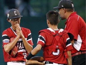 Whalley Major Allstars pitcher Ian Huang reacts as he talks with manager Mike Marino and catcher Andre Juco as he his taken out after giving up a three-run home run to Panama's Adan Sanchez during the second inning of Friday's international action at the Little League World Series tournament in South Williamsport, Pa. The Canadian squad lost 8-3 and will play Spain on Saturday afternoon.