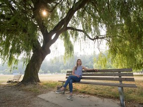 Kelsey Innes, sister of Brenna Innes, sits on a bench Aug. 22 dedicated to Brenna at Spanish Banks in Vancouver.