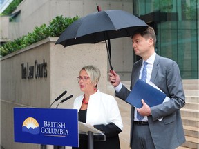 Attorney General David Eby and Judy Darcy, Minister of Mental Health and Addictions, at a news conference at B.C. Supreme Court in Vancouver on Aug. 29. The province has launched a class-action lawsuit against drug companies, claiming their marketing of opioids has led to devastating impacts on the lives of thousands of British Columbians, including overdose deaths.
