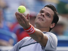 Milos Raonic serves to Novak Djokovic at the Western & Southern Open, Friday, Aug. 17, 2018, in Mason, Ohio. (AP Photo/John Minchillo)