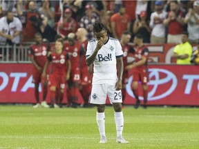 Vancouver Whitecaps' Yordi Reyna reacts as Toronto FC's Sebastian Giovinco, rear left, celebrates scoring his team's second goal during first half action in the Canadian Championship Final second leg in Toronto on Wednesday, August 15 , 2018.