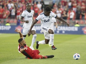 Vancouver Whitecaps forward Alphonso Davies, right, leaps Toronto FC defender Justin Morrow challenge during first half action in the Canadian Championship Final's second leg in Toronto on Wednesday, August 15, 2018.