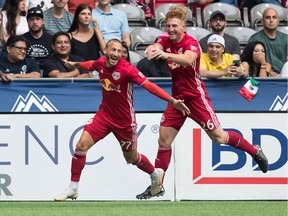 New York Red Bulls' Daniel Royer, left, and Tim Parker celebrate Royer's second goal against the Vancouver Whitecaps on Saturday. Royer tied the MLS match at B.C. Place Stadium in the 90th minute. The teams played to a 2-2 draw.